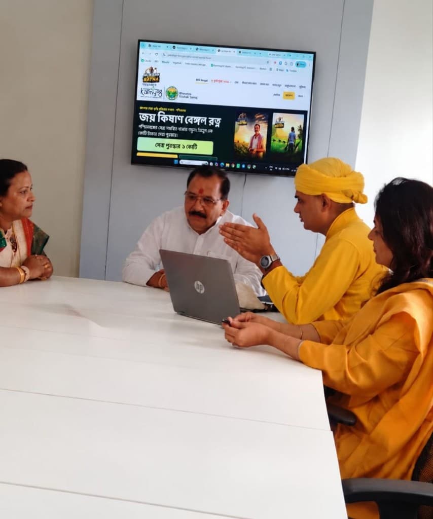 Four people reviewing the Jai Kisan Bengal Ratna website on a wall screen